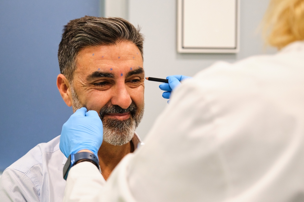 Préparation du visage d'un homme pour injection de Botox